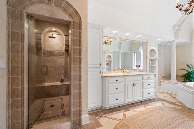 bathroom featuring ornate columns, tile patterned flooring, vanity, and a shower with shower door