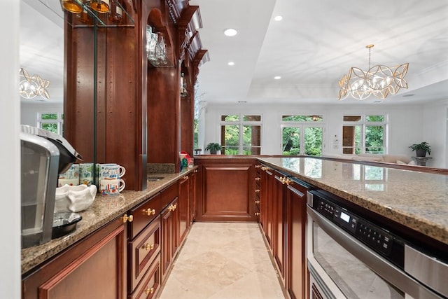 kitchen featuring light stone countertops, a notable chandelier, pendant lighting, and plenty of natural light