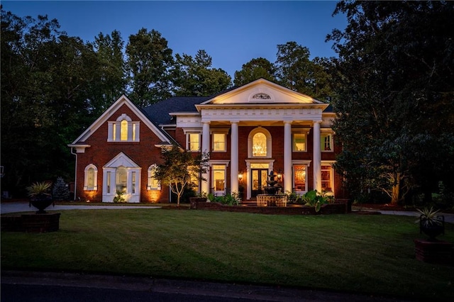 greek revival inspired property featuring a lawn