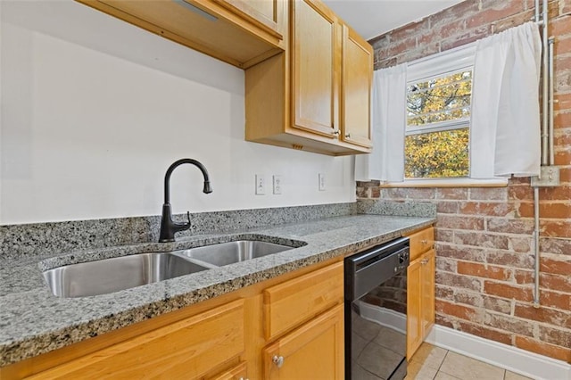 kitchen with sink, light tile patterned floors, black dishwasher, light stone counters, and brick wall