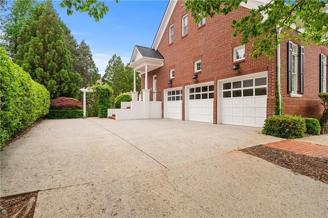 view of property exterior with brick siding, driveway, and a garage