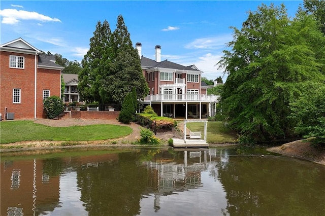 exterior space with a yard, a water view, and central air condition unit