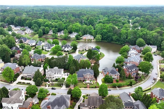 birds eye view of property featuring a residential view, a water view, and a wooded view