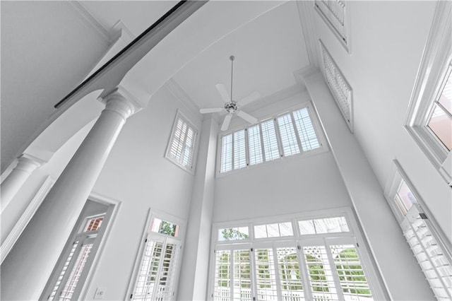 interior details with ceiling fan, ornamental molding, and ornate columns