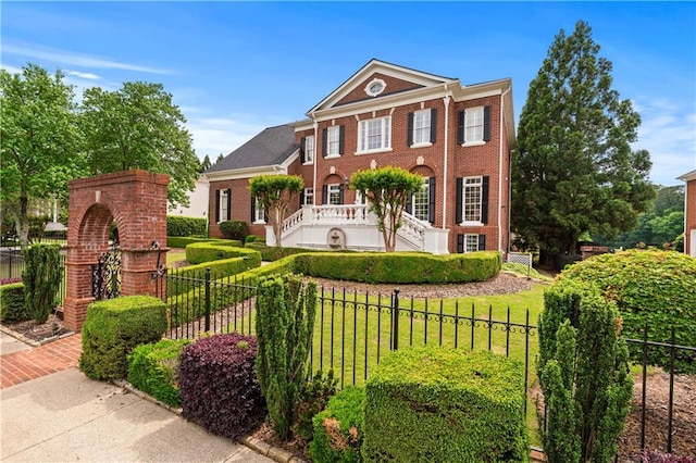 view of front of property featuring fence, a front lawn, and brick siding