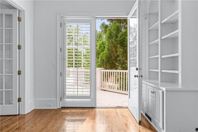 doorway with light wood-style floors and baseboards