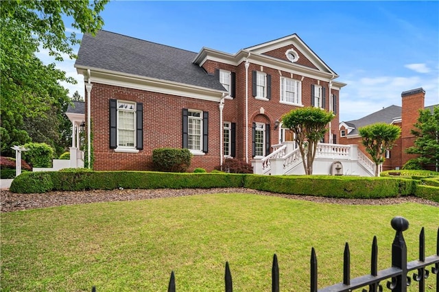 view of front facade featuring brick siding and a front lawn