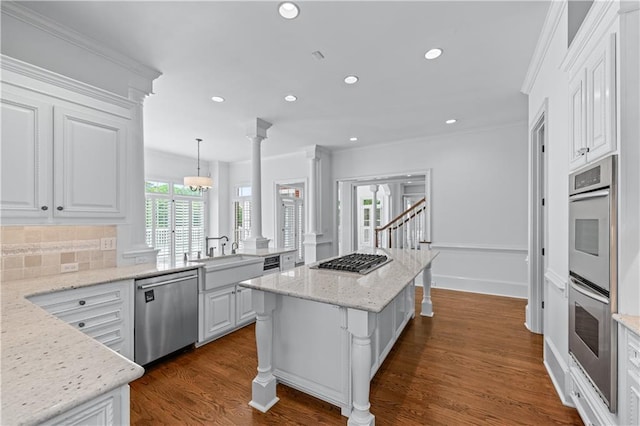 kitchen with crown molding, white cabinetry, appliances with stainless steel finishes, and a sink