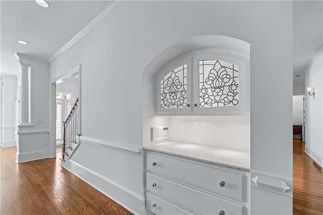 room details featuring baseboards, ornamental molding, ornate columns, and wood finished floors