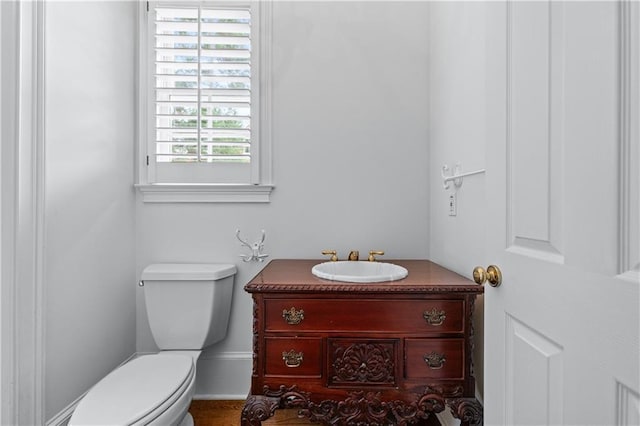 half bathroom with vanity and toilet