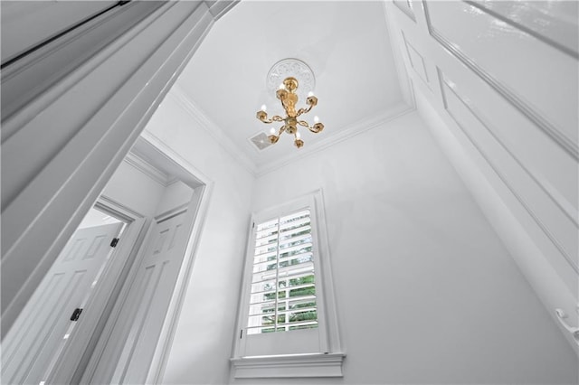 details featuring an inviting chandelier, ornamental molding, and visible vents