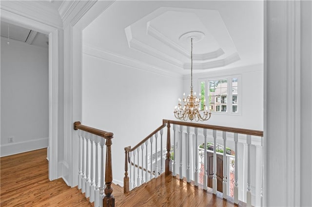 interior space with a notable chandelier, an upstairs landing, wood finished floors, and attic access