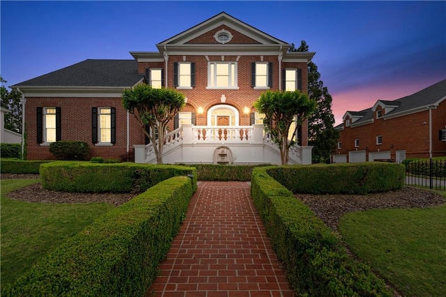 view of front facade with fence, a front yard, and brick siding