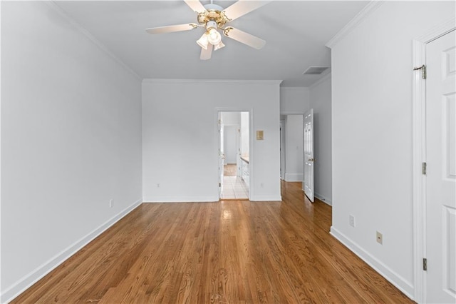 unfurnished bedroom featuring crown molding, baseboards, wood finished floors, and visible vents