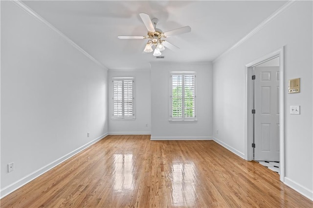 empty room featuring visible vents, ornamental molding, baseboards, ceiling fan, and light wood finished floors