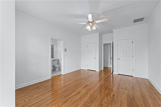 unfurnished bedroom with ornamental molding, connected bathroom, light wood-style flooring, and visible vents