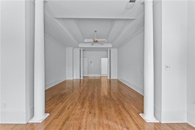 unfurnished living room featuring ceiling fan, visible vents, a raised ceiling, light wood-style floors, and ornate columns