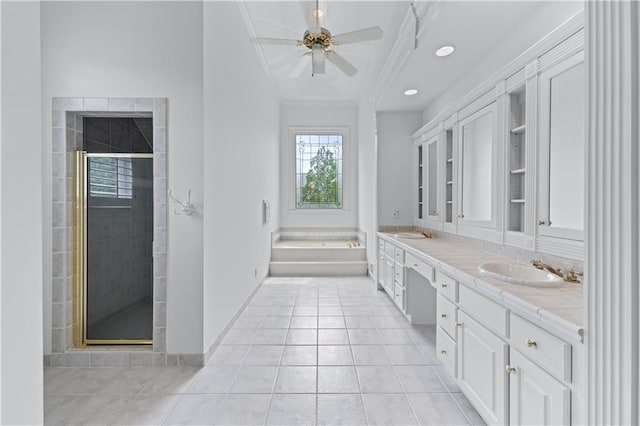 bathroom with double vanity, ornamental molding, ceiling fan, a shower stall, and a sink