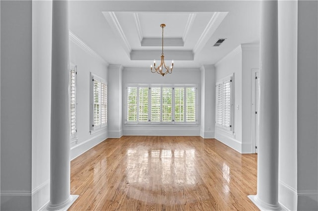 unfurnished dining area featuring visible vents, an inviting chandelier, wood finished floors, baseboards, and a tray ceiling