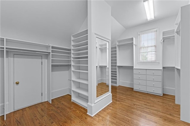 walk in closet featuring vaulted ceiling and wood finished floors