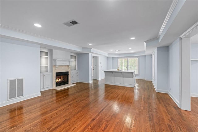 unfurnished living room with crown molding, recessed lighting, visible vents, and dark wood-style floors