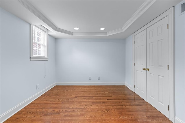 unfurnished bedroom featuring visible vents, crown molding, wood finished floors, a raised ceiling, and recessed lighting