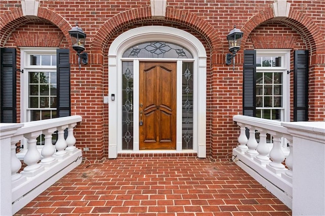entrance to property featuring brick siding