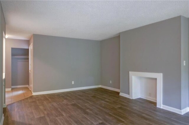 unfurnished room with a textured ceiling and dark hardwood / wood-style floors