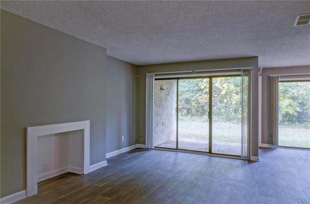 unfurnished living room featuring a textured ceiling and dark wood-type flooring