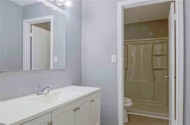 bathroom with vanity, toilet, and walk in shower