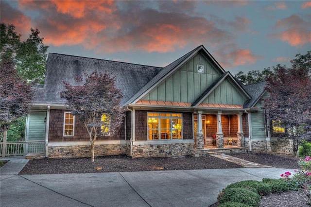 craftsman inspired home with metal roof, a porch, roof with shingles, board and batten siding, and a standing seam roof