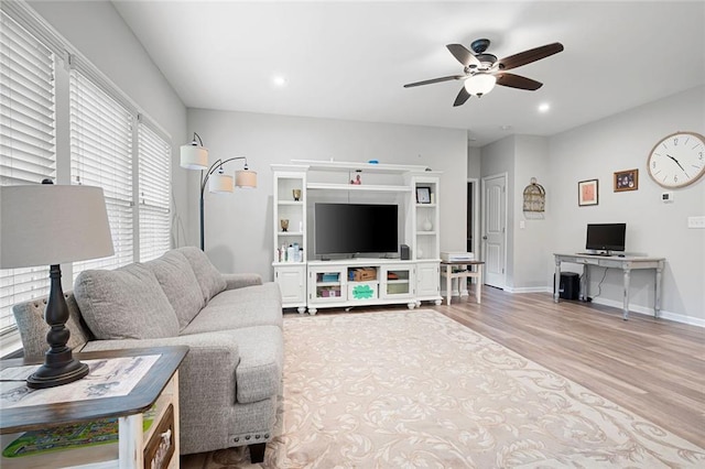 living room with ceiling fan and light hardwood / wood-style flooring