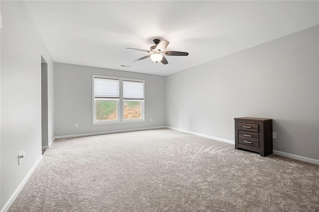 empty room with ceiling fan and light carpet