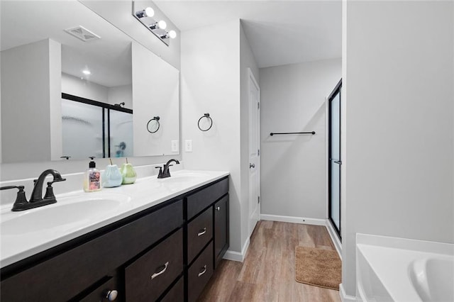 bathroom featuring hardwood / wood-style floors, vanity, and separate shower and tub