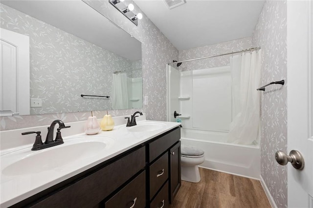 full bathroom with hardwood / wood-style floors, shower / bath combo, toilet, and vanity