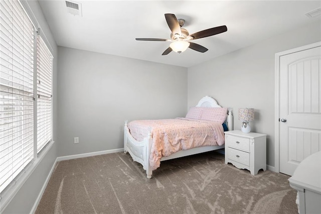 carpeted bedroom with multiple windows and ceiling fan