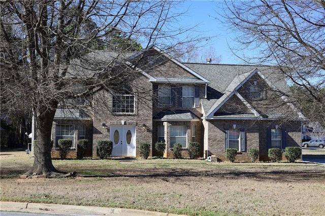 view of front of property with brick siding and a front lawn