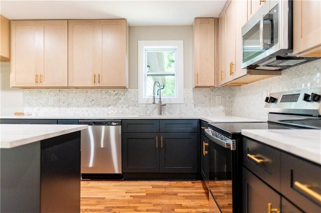 45 Driskell Ave, Mableton, GA 30126 - kitchen featuring appliances with stainless steel finishes, light countertops, light wood-style flooring, and tasteful backsplash