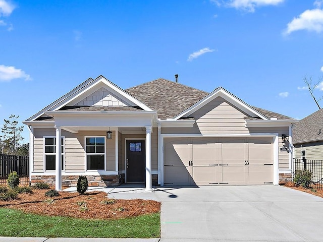 view of front of property featuring fence, a porch, concrete driveway, a garage, and stone siding