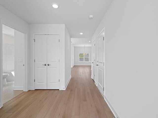 hall featuring recessed lighting, light wood-style flooring, and baseboards