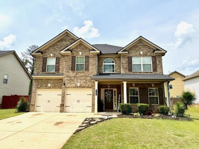 558 Hideaway Dr, Jonesboro, GA 30238 - craftsman inspired home featuring a garage, driveway, brick siding, and a porch