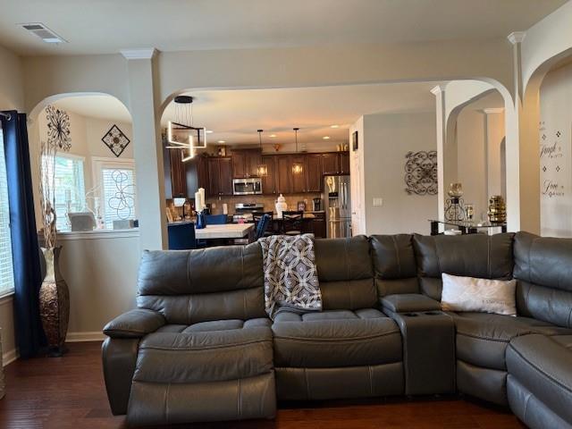 558 Hideaway Dr, Jonesboro, GA 30238 - living area featuring arched walkways, baseboards, and dark wood-style floors