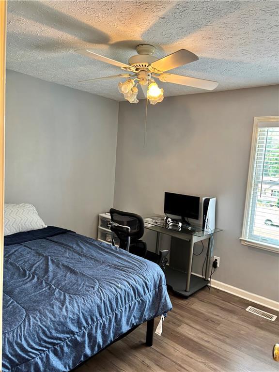 403 Hickory Walk, Woodstock, GA 30188 - bedroom with wood finished floors, a textured ceiling, ceiling fan, and baseboards