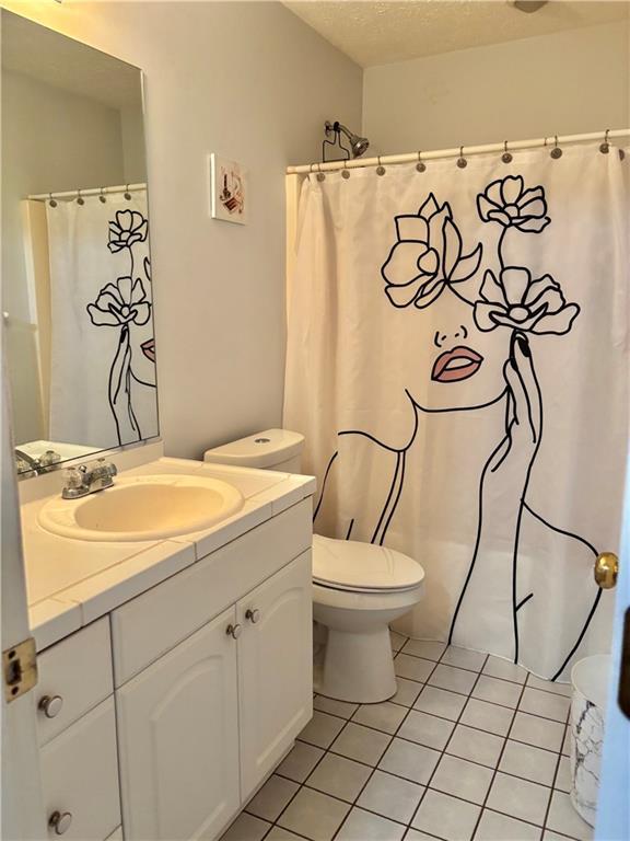 403 Hickory Walk, Woodstock, GA 30188 - bathroom with vanity, toilet, tile patterned floors, a textured ceiling, and curtained shower
