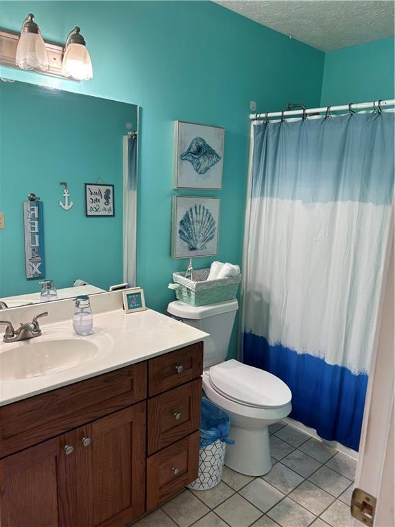403 Hickory Walk, Woodstock, GA 30188 - full bath featuring vanity, tile patterned flooring, toilet, a textured ceiling, and a shower with shower curtain
