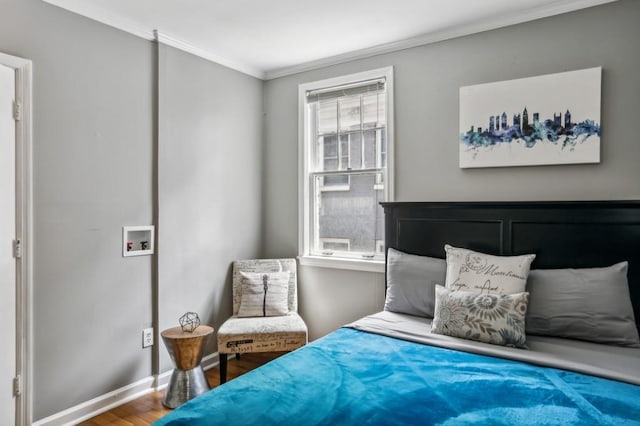 bedroom with ornamental molding, wood finished floors, and baseboards