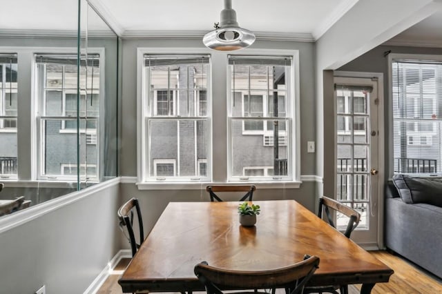 dining space with ornamental molding, baseboards, and wood finished floors