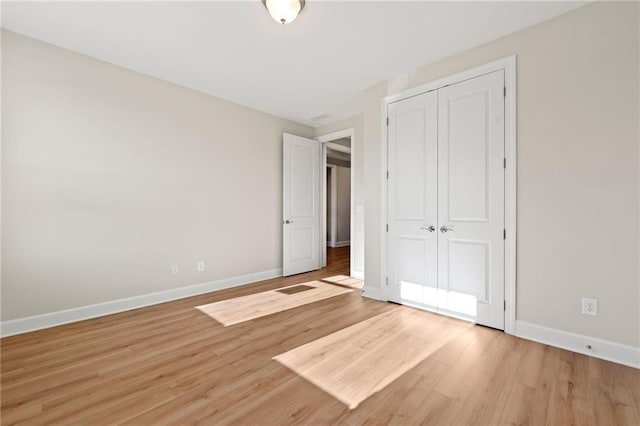 198 Bear Way, Hoschton, GA 30548 - unfurnished bedroom with baseboards, light wood-type flooring, and a closet