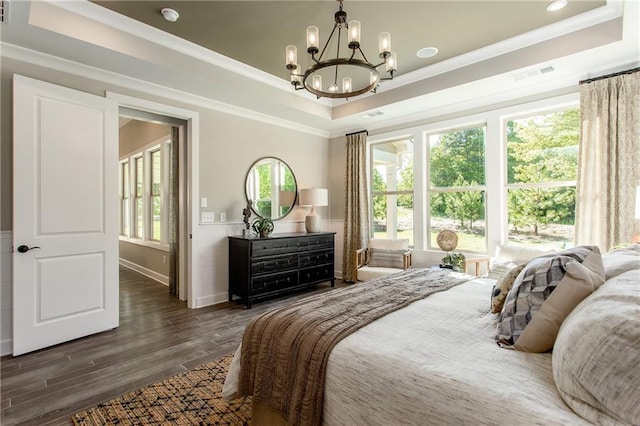 bedroom with a notable chandelier, a raised ceiling, and crown molding