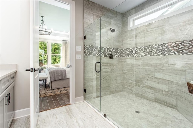 bathroom featuring a chandelier, vanity, and walk in shower